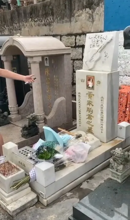 涉案光頭少年用腳踩歌迷獻上的鮮花祭品之餘，更用錘扑遺照，導致遺照毀爛。（網上片段）