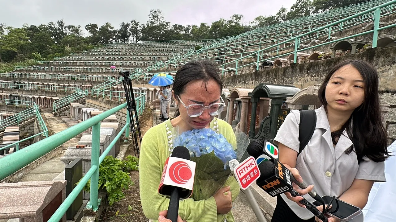 由四川來港的阿英，驚悉偶像填墓被毀，手持鮮花，泣不成聲。（馬耀文攝）