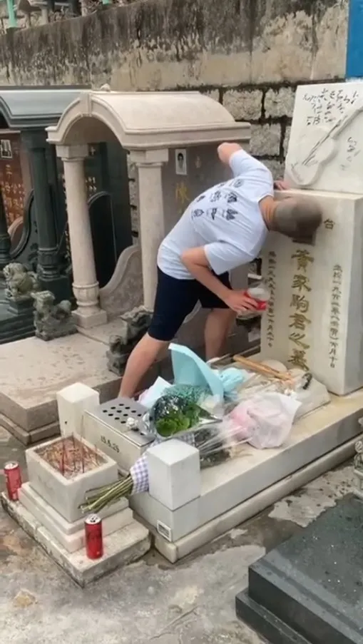 刑毀片段被上載到網絡，一名光頭男子自稱「社會破壞者」，粗言辱罵黃家駒，向墓碑淋潑汽水後上前舔走。（網上片段）