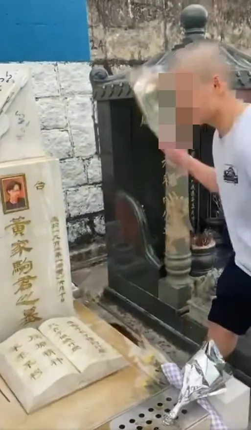 一名光頭男子自稱「社會破壞者」，粗言辱罵黃家駒，向墓碑淋潑汽水後上前舔走，用腳踩歌迷獻上的鮮花祭品。（網上片段）