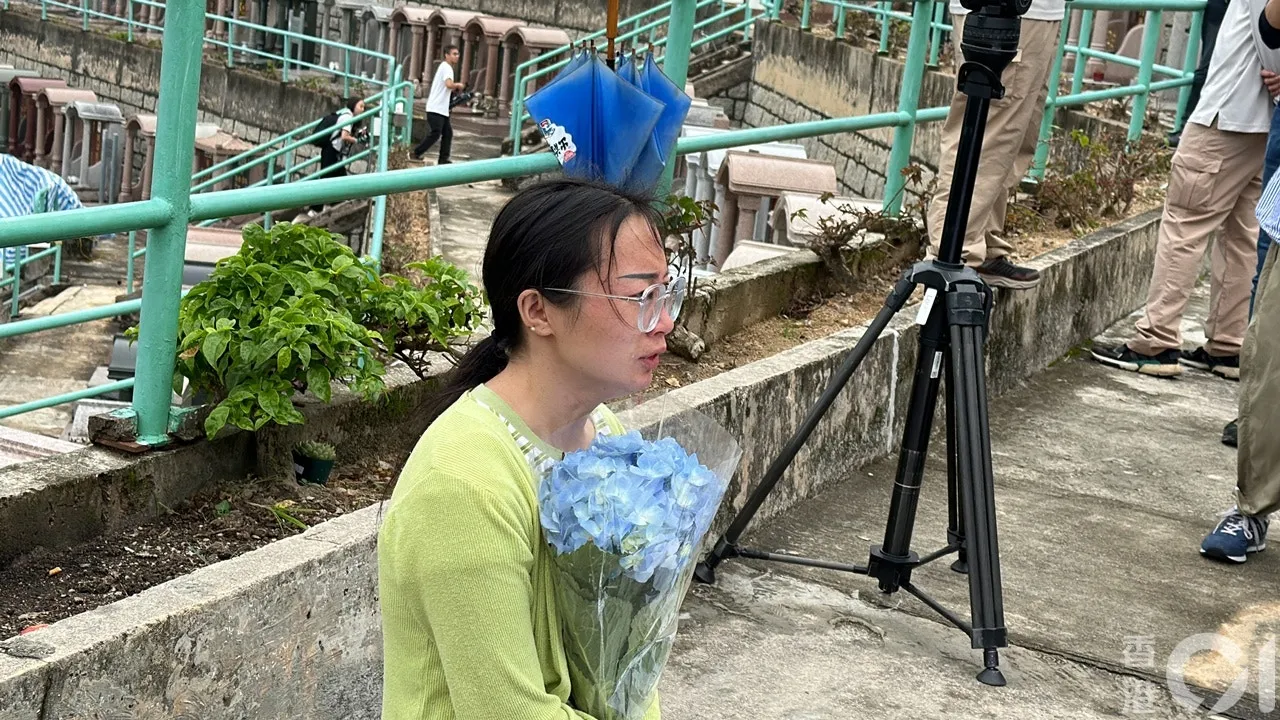 由四川來港的阿英，驚悉偶像填墓被毀，手持鮮花跑地致祭，泣不成聲。（馬耀文攝）