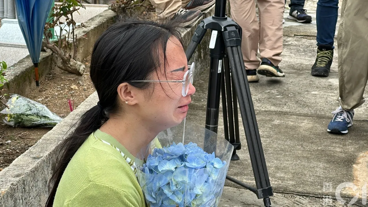 由四川來港的阿英，驚悉偶像填墓被毀，手持鮮花跑地致祭，泣不成聲。（馬耀文攝）