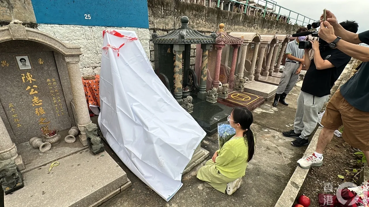 由四川來港的阿英，驚悉偶像填墓被毀，手持鮮花，泣不成聲。（馬耀文攝）